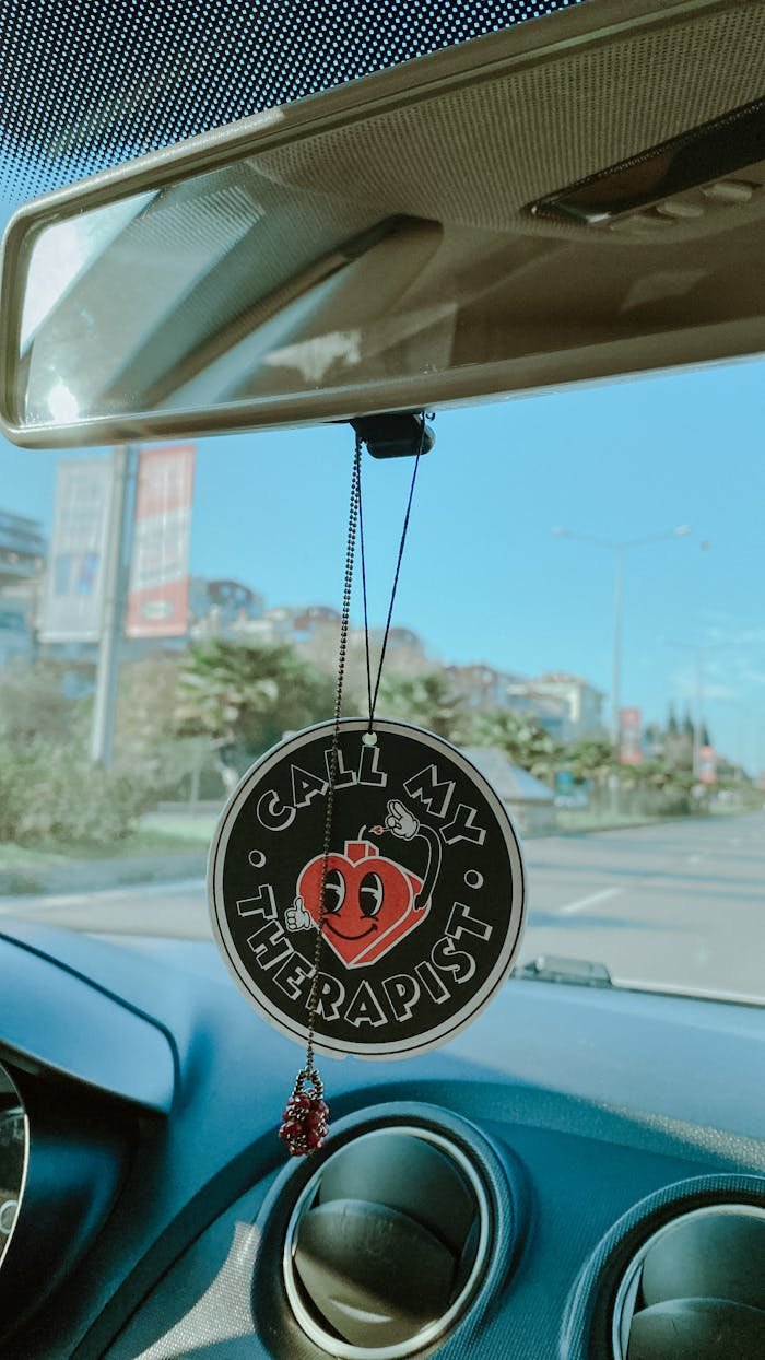 Air freshener in car interior with 'Call My Therapist' message